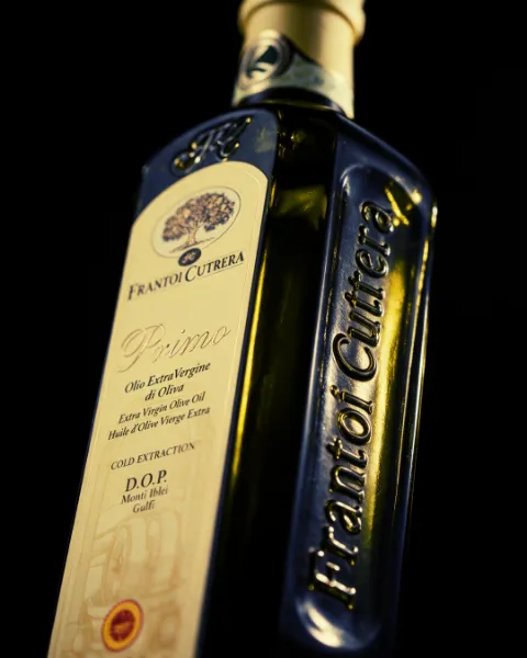 Foto de muestra: botella de aceite de oliva con iluminación de estudio sobre fondo negro